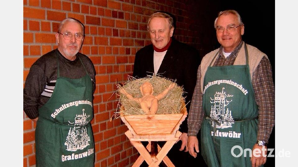Josef Troidl (links) und Werner Biersack (rechts) haben das Jesuskind mit Krippe an Pfarrer Hans Bayer (Mitte) im Dezember 2003 übergeben. Seither ist es jedes Weihnachten zu bewundern. Bild: rgr