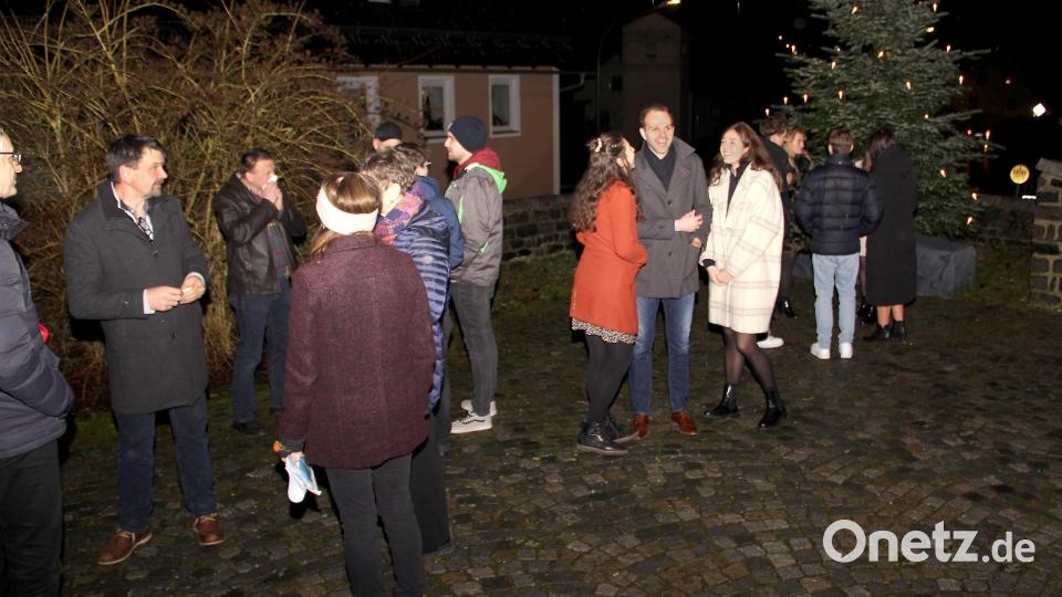 Traditionell nach der Christmette werden beim Weihnachtsbaum am Kirchplatz die weihnachtlichen Wünsche ausgetauscht. Der sanfte Regen bereitete den Begegnungen jedoch ein rasches Ende. Bild: Josef Böhm