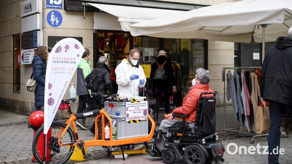 Intensivpfleger Oliver Sablowski (M) testet eine Passantin mit einem Antigen-Schnelltest. Bild: Daniel Vogl/dpa