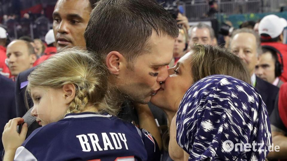 Tom Brady hält Tocher Vivian auf dem Arm und küsst seine Frau Gisele Bündchen, die Bradys Mutter Galynn (vorn) den Arm über die Schulter gelegt hat. Bild: Patrick Semansky/AP/dpa