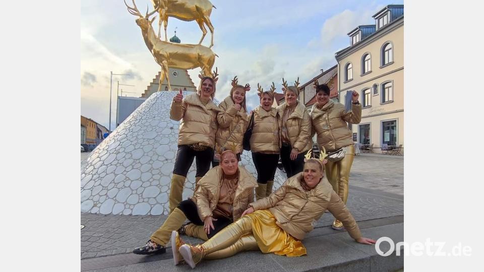 Die vergoldeten Hirsche des Monte-Hirschschau-Brunnens haben Narrhalla-Präsidentin Regina Merkl (hinten rechts) animiert, zusammen mit sechs weiteren goldenen Narrhalla-Frauen Hirschaus Innenstadt am Unsinnigen Donnerstag unsicher zu machen. Bild: u