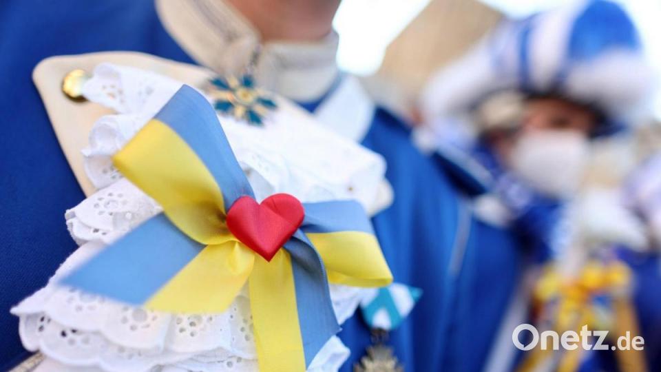 Eine Karnevalistin trägt eine Schleife in den ukrainischen Landesfarben bei der Friedensdemonstration am Rosenmontag. Bild: Rolf Vennenbernd/dpa