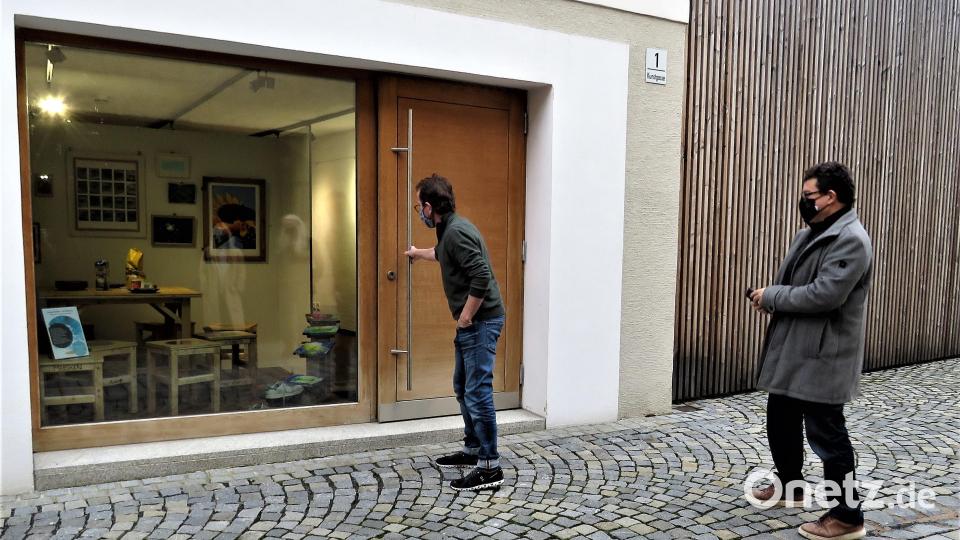 Vereinsvorsitzender Wolfgang Horn und sein stellvertreter Markus Braun schauen sich nach getaner Arbeit das Ergebnis des neuen Kunstschaufensters von außen an. Bild: ubb