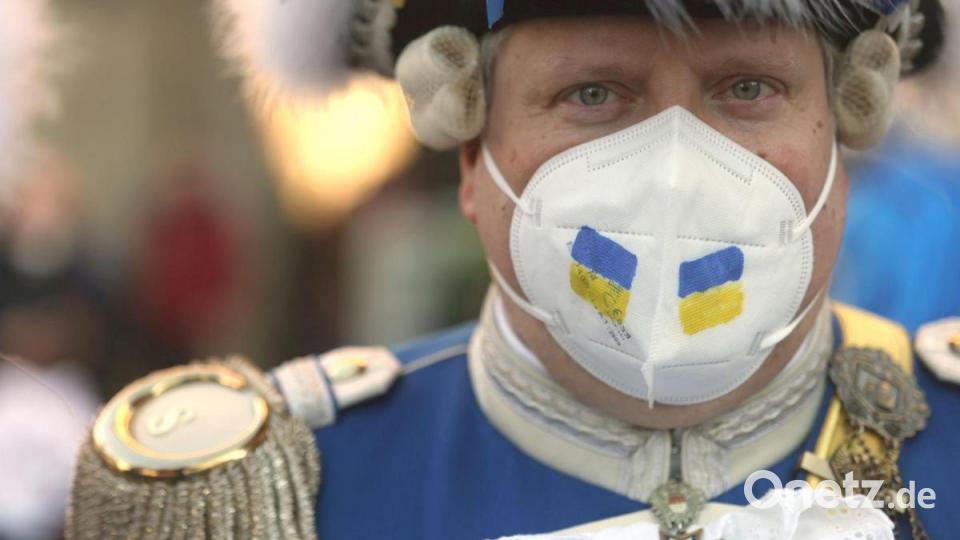 Ein Karnevalist trägt die ukrainischen Landesfarben bei der Friedensdemonstration am Rosenmontag. Bild: Oliver Berg/dpa