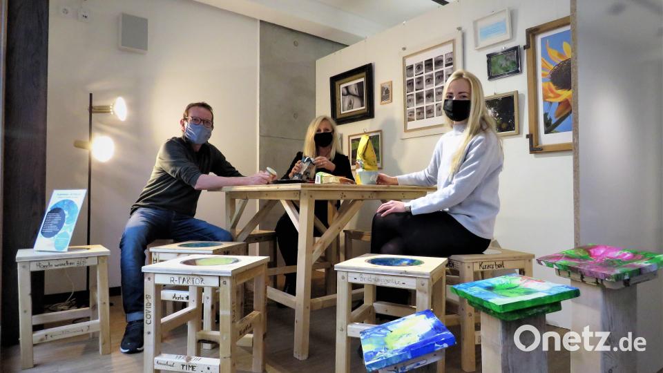 Vereinsvorsitzender Wolfgang Horn, Schulleiterin Claudia Strobl-Dietrich und Lehrerin Alena-Sarah Kneidl (von links) sitzen &quot;Probe&quot; im Kunstschaufenster. Die Lehrerinnen haben sich entschlossen, die Schülerarbeiten als eine ganz normale Alltagsszenerie ins Rampenlicht zu rücken. Bild: ubb