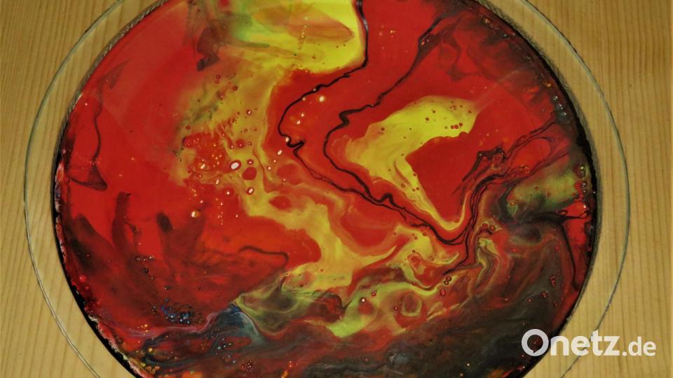Die Kunsttechnik &quot;Pouring&quot; ist dem Zufall unterworfen. Die Farbe läuft wie von selbst, je nachdem wie das Objekt, hier der Teller, gedreht wird. Bild: ubb