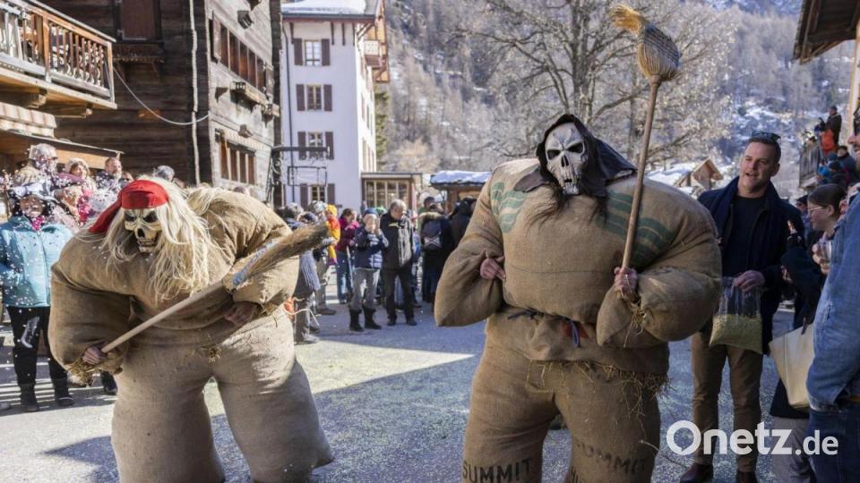 Kostümierte Menschen nehmen am traditionellen Karnevalsumzug im Schweizer Evolene teil, bei dem sie durch das Dorf ziehen, um die bösen Geister des Winters zu vertreiben. Bild: Cyril Zingaro/KEYSTONE/dpa