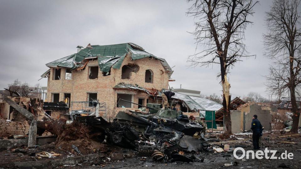 Ein Mann betrachtet die ausgebrannten Überreste russischer Militärfahrzeuge in Butscha. Bild: Serhii Nuzhnenko/AP/dpa