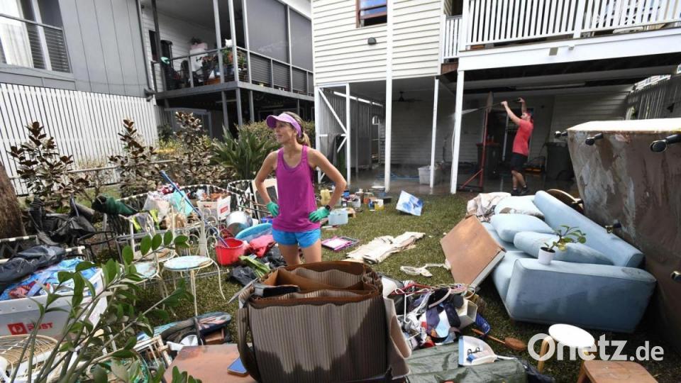 Wegen der Überschwemmungen in Australien müssen viele Bewohner ihre Häuser aufräumen. Ein Mann wird noch immer vermisst, neun Menschen sind tot und mehr als 1100 befinden sich in Evakuierungszentren. Bild: Darren England/AAP/dpa