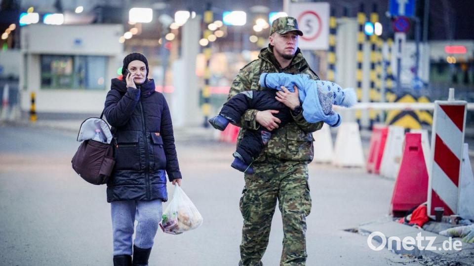 Ein polnischer Soldat trägt ein Kind über den ukrainsch-polnischen Grenzübergang in Medyka. Bild: Kay Nietfeld/dpa