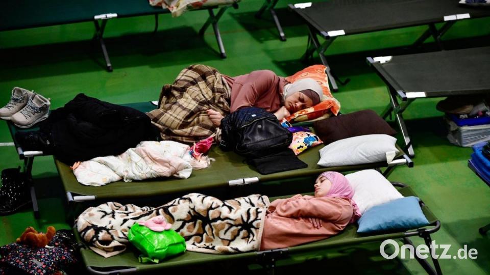 Nach einer teilweise tagelangen Flucht aus dem Kriegsgebiet kommen geflüchtete Frauen aus der Ukraine auf Feldbetten in einer umfunktionierten Turnhalle in Zahony im Nordosten von Ungarn endlich zur Ruhe. Bild: Marton Monus/dpa
