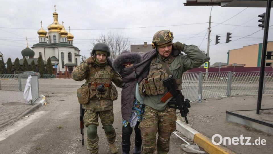 Ukrainische Soldaten helfen einer älteren Frau in der Stadt Irpin, Ukraine. Bild: Andriy Dubchak/AP/dpa