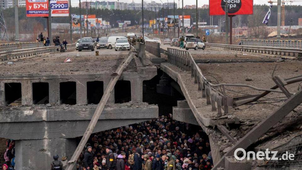 Ukrainer drängen sich unter einer zerstörten Brücke, als sie versuchen, über den Fluss Irpin in den Außenbezirken von Kiew zu fliehen. Bild: Emilio Morenatti/AP/dpa