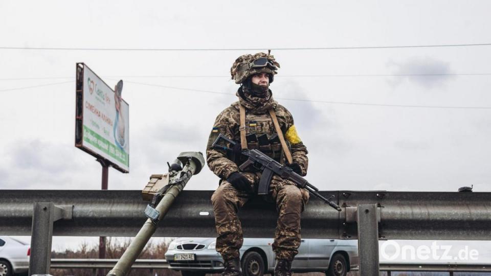 Ein ukrainischer Soldat macht eine kurze Pause am Straßenrand in Irpin. Bild: Diego Herrera/XinHua/dpa