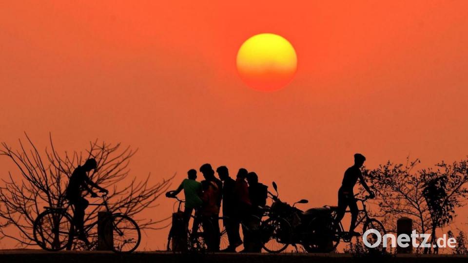 Der Sonnenuntergang im indischen Nagaon taucht den Himmel in ein tiefes Orange. Bild: -/XinHua/dpa
