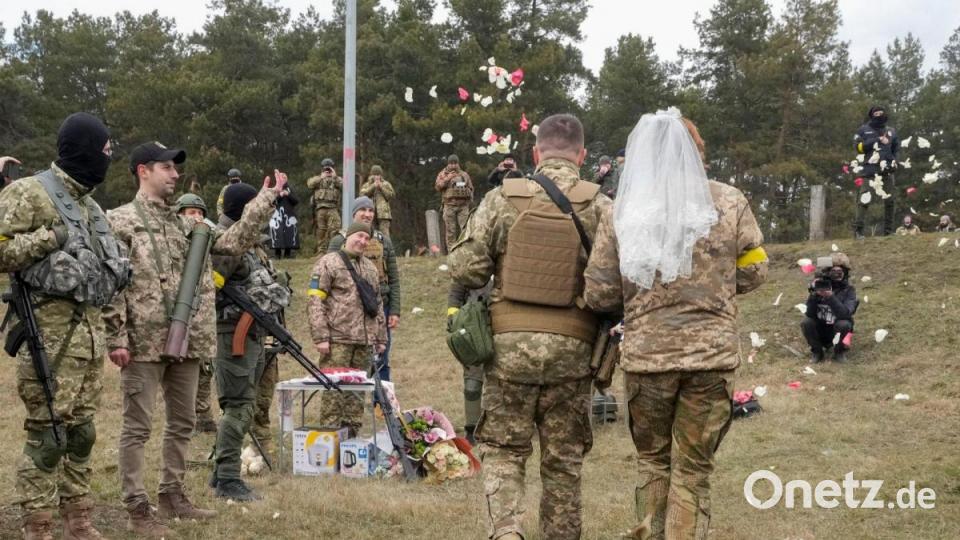 Auch in Kriegszeiten wird geheiratet: Zwei Mitglieder der ukrainischen Territorialen Verteidigungskräfte gaben sich an einem Kontrollpunkt in Kiew das Ja-Wort. Bild: Efrem Lukatsky/AP/dpa