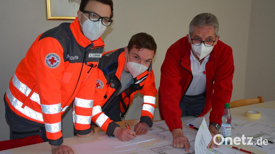 Helfer des Roten Kreuzes bereiten mit Zimmerplänen und Grundrissen die Ankunft der Flüchtlinge vor. Bild: jr