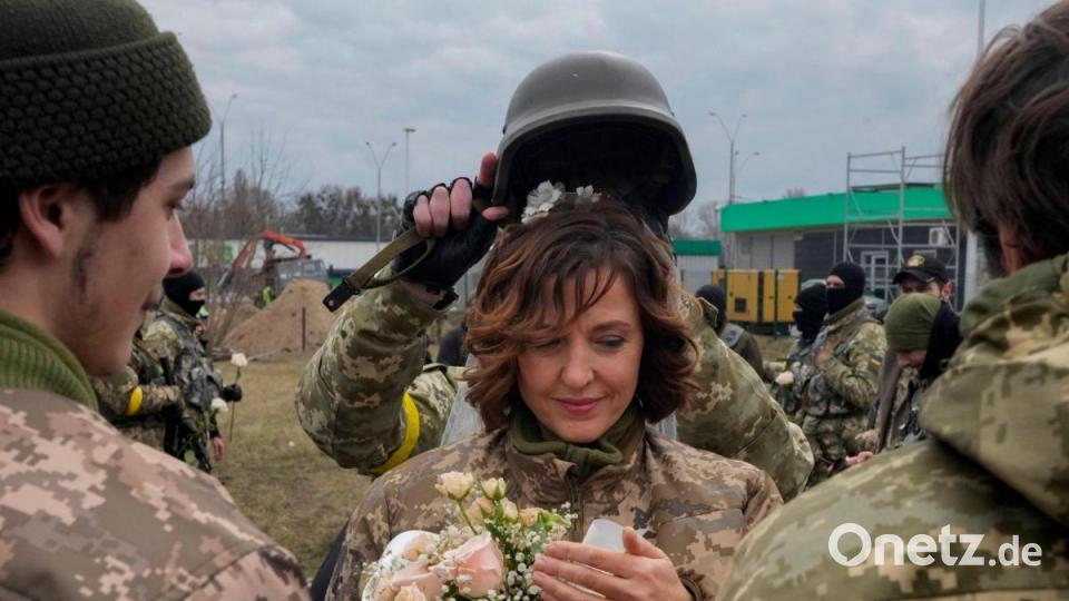 Lesia Ivashchenko und Valerii Fylymonov während ihrer Hochzeitszeremonie an einem Kontrollpunkt in Kiew. Bild: Efrem Lukatsky/AP/dpa