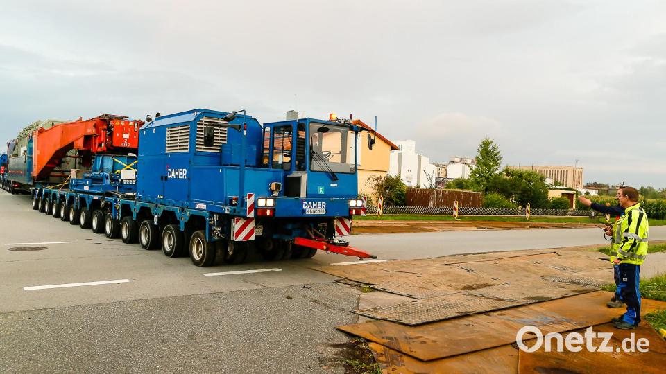 Gut 55 Meter und rund 546 Tonnen schwer lang ist der Schwerlastzug, der am Montagabend vom Müllkraftwerk durch die Alustraße (Bild) Richtung Umspannwerk Büchelkühn rollt. Transportiert wird ein 273 Tonnen schwerer Trafo, der in einem Tieflader mit Tragschnäbeln (rot) auf zwei jeweils 13-achsigen, je 700 PS starken Zugmaschinen ruht. Bild: Hösamer