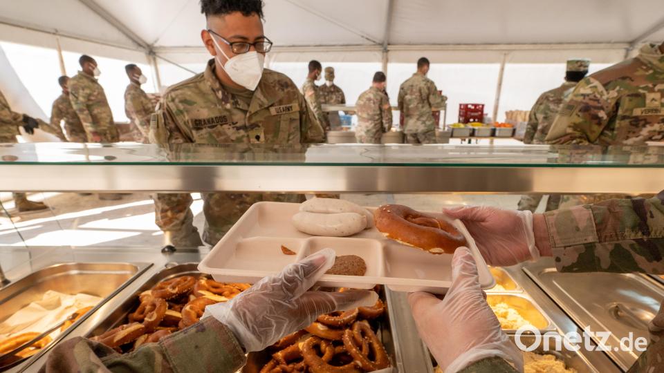 US-Soldaten bekommen in einem Zelt auf dem Gelände des Truppenübungsplatzes Grafenwöhr Essenstabletts - darauf jeweils Weißwürste, süßer Senf, Obatzda und eine Brezel. Mit dem traditionellen Weißwurstfrühstück hat Bayerns Ministerpräsident Söder rund 4000 Soldaten der US-Armee in der Oberpfalz willkommen geheißen. Bild: Armin Weigel/dpa