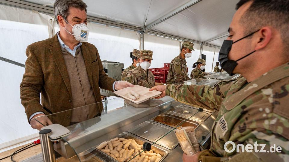 Markus Söder (CSU), Ministerpräsident von Bayern, reicht einem US-Soldaten ein Weißwurstfrühstück. Bild: Armin Weigel/dpa