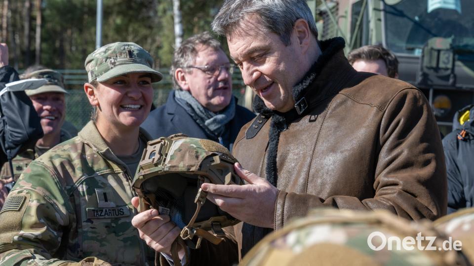 Markus Söder (CSU), Ministerpräsident von Bayern, hält auf dem Gelände des Truppenübungsplatzes Grafenwöhr einen Helm von US-Soldaten. Der Standort in der Oberpfalz ist der größte der US-Armee in Europa. Bild: Armin Weigel/dpa