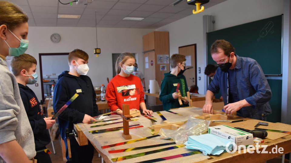 Künstler Wolfgang Horn erklärte den Jugendlichen, wie die beiden Holzbalken ineinandergreifen und damit zu einem Kreuz verbunden werden. Bild: ubb