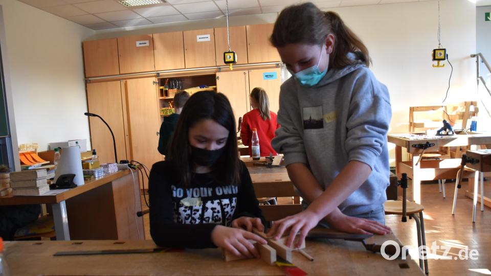 Alina und Marie (v. li.) halfen sich gegenseitig beim Fertigstellen der Kreuze. Es mussten nur noch die Glasstreifen in die Fugen der Balken geschobern werden. Bild: ubb