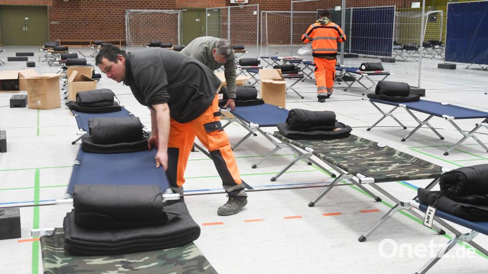 In der Mehrzweckhalle in Weiden stellen Helfer Feldbetten für die Aufnahme von Menschen auf, die vor dem Krieg aus der Ukraine flüchten. Bild: Gabi Schönberger