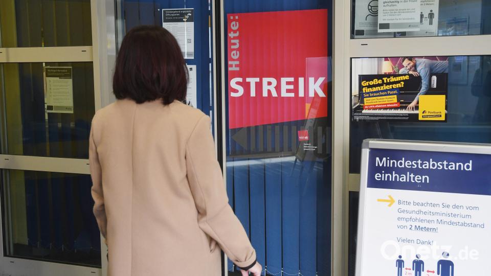 Ein rotes Plakat mit der Aufschrift "Streik" hängt am Eingang zur Postbankfiliale in Weiden. Bild: Gabi Schönberger