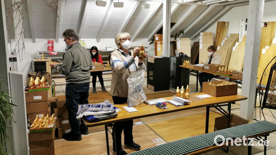 In einer &quot;Arbeitsstraße&quot; werden die Goldhasen von Mitgliedern des Wirtschaftsforums Oberviechtach mit einem individuellen Namensbändchen versehen. Bild: Bianca Liebermann/exb