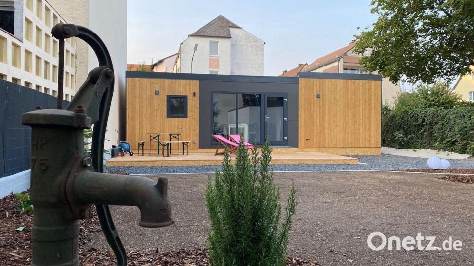 Blick durch den Garten auf das Tiny-Häuschen. Der uralte Brunnen ist reaktiviert. Das Wasser lässt sich für den neu gestalteten Garten nutzen. Bild: Rippl Architektur