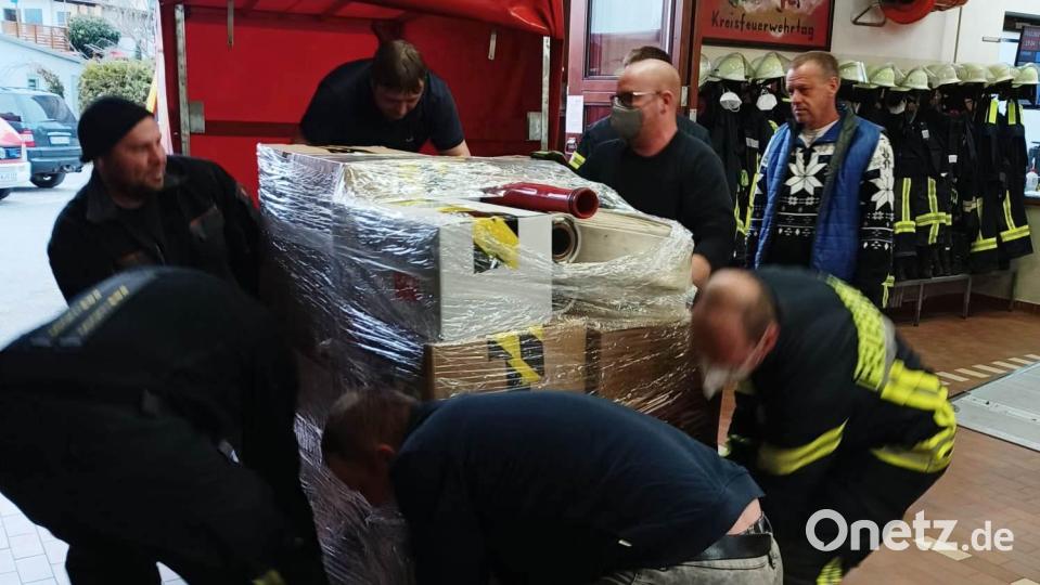 Im Feuerwehrhaus Oberwildenau verpacken die Wehrmitglieder die gespendeten Hilfsmittel transportsicher in einem Folienüberzug. Bild: bey