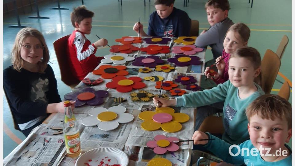 Zehn Kinder basteln in der Turnhalle Schmuck für den Osterbrunnen. Bild: lei