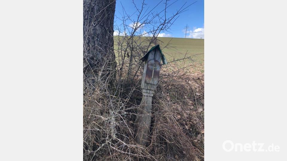 Das alte Feldkreuz ist instabil, lehnt nur noch an einem Baum. Bild: hzi