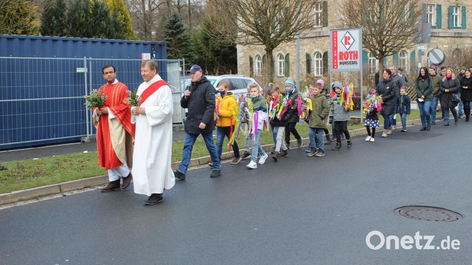 In der Palmprozession zogen die Kommunionkinder zusammen mit Pfarrer Pater Anish George und Diakon Rudolf Hoffmann zur Pfarrkirche Bild: soj