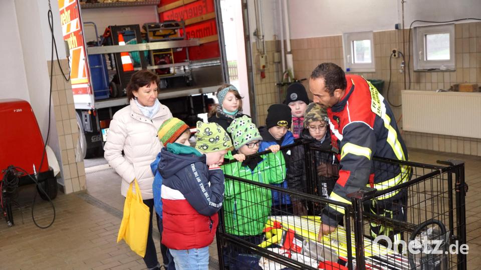 Die Feuerwehrfahrzeuge können nicht alles mitnehmen, was für einen Einsatz gebraucht werden könnte. Deshalb gibt es Rollcontainer mit diverser Ausrüstung, die schnell entsprechend dem Auftrag verladen werden können. Zweiter Kommandant Christopher Hörl (rechts) erklärte den Kindern und Klassenlehrerin Kerstin Zaus (links) den Inhalt einer der Boxen. Bild: bkr