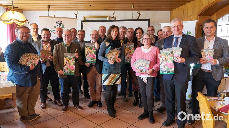 Die Projektmanager der Öko-Modellregion Steinwald stellen ihr neues Jahresprogramm „Bio-Sommer in der Steinwald-Allianz“ vor den Bürgermeistern der Steinwald-Allianz vor; (vorne Mitte im blauen Kleid: Projektleitung Öko-Modellregion Steinwald Elisabeth Waldeck, links daneben mit Plakat Günther Erhardt und rechts daneben im rosa Pullover Eva Gibhardt, beide Mitarbeiter der Öko-Modellregion). Bild: Steinwald-Allianz/exb