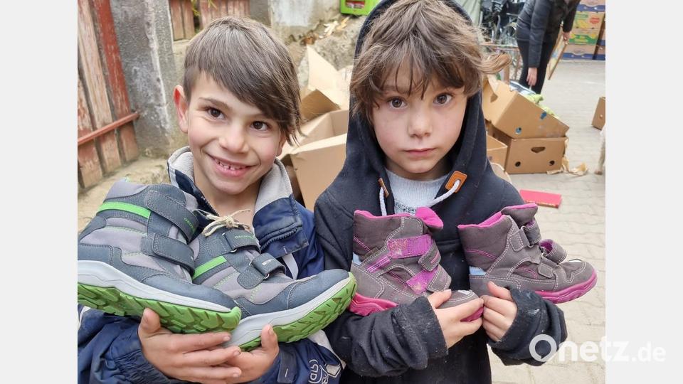 Die beiden Jungen zeigen stolz ihre neuen, warmen Winterschuhe. Bild: exb
