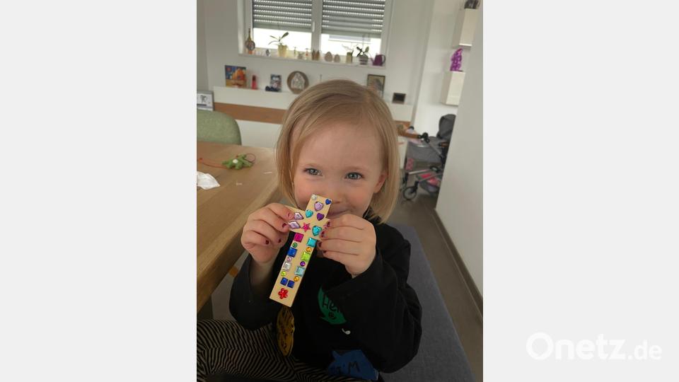 Ida Demel verziert ihr Holzkreuz mit Klebepailletten. Insgesamt hat das Team Junge Familie der Kolpingsfamilie Neustadt 43 Kinder mit Bastelpaketen zu Ostern beliefert. Bild: prh
