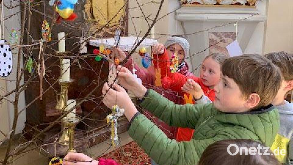 Jedes der 15 Kinder darf seinen selbst gebastelten Osterschmuck an der Birke anbringen. Bild: gz