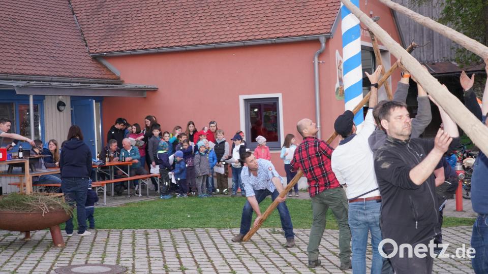 Die Albersriether Dorfjugend wartet gespannt, bis der Maibaum steht. Nachdem der Kraftakt der starken Männer geschafft ist, singen sie "Der Mai ist gekommen". Bild: fvo