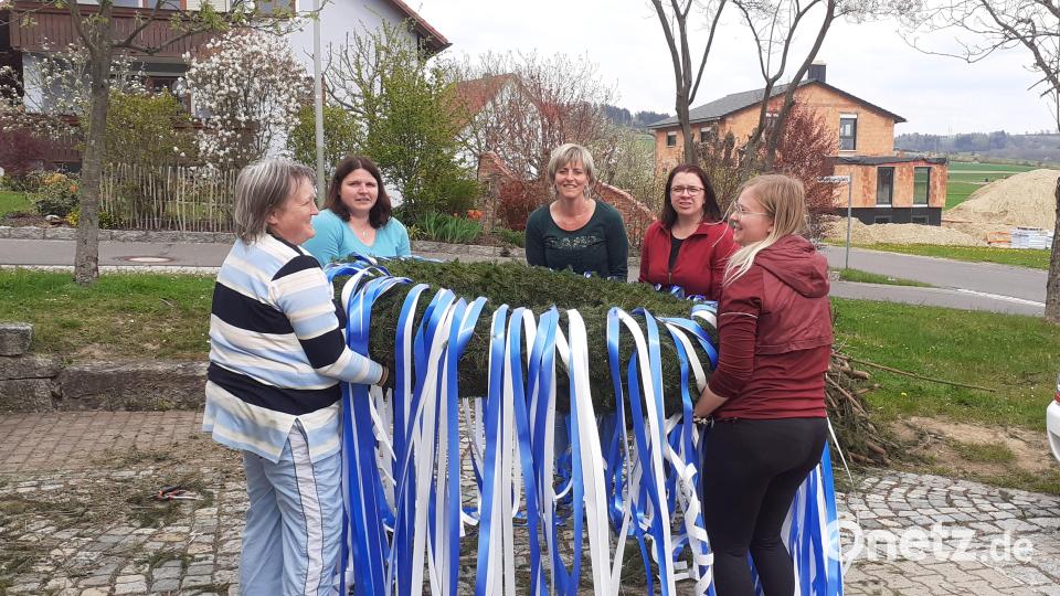 Bereits am Samstag trafen sich (von links) Christine Braunreuther, Daniela Wörl, Sandra Zaus, Bianca Wörl und Lisa Abramowksi von der Feuerwehr, um den Maibaumkranz zu binden und mit blau-weißen Bändern zu schmücken. Bild: ak