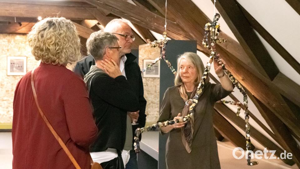 Die Künsterlin erklärt den Vernissage-Gästen das Kunstwerk &quot;Grenzüberschreiter&quot;. Bild: Susanne Forster