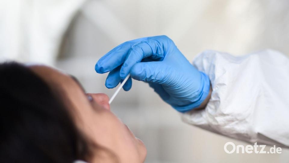 Eine Mitarbeiterin eines Testzentrums nimmt einen Nasenabstrich für einen Coronatest: Im Landkreis Tirschenreuth gab es innerhalb einer Woche 526 positive Coronatests. Bild: Kira Hofmann/dpa