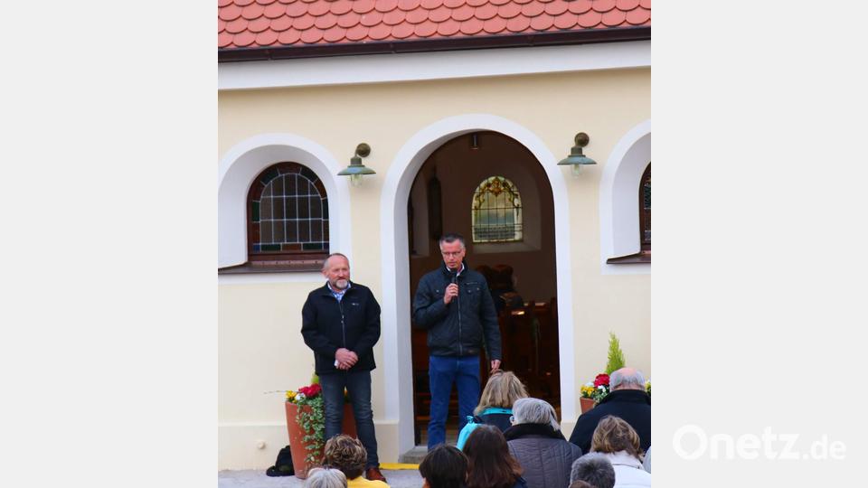 Unter dem Beifall der Anwesenden würdigt Bürgermeister Hermann Falk (rechts) die großen Verdienste von Ortssprecher Erich Stauber (links) um die Kapellenrenovierung. Bild: u