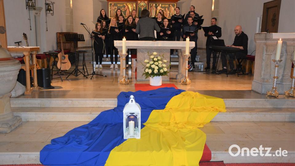 Der 21-köpfige Chor „Grazie A Dio“ unter der Leitung von Michaela Burger wurde beim Benefizkonzert von Christoph Habel am E-Piano begleitet. Auf den Stufen des Altars lag die Flagge der Ukraine, darauf stand eine Kerze. Bild: jr