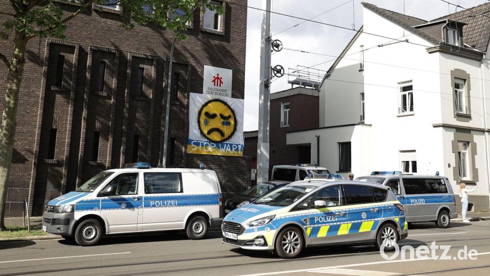 Polizeifahrzeuge stehen vor dem Don-Bosco-Gymnasium in Essen. Bild: David Young/dpa