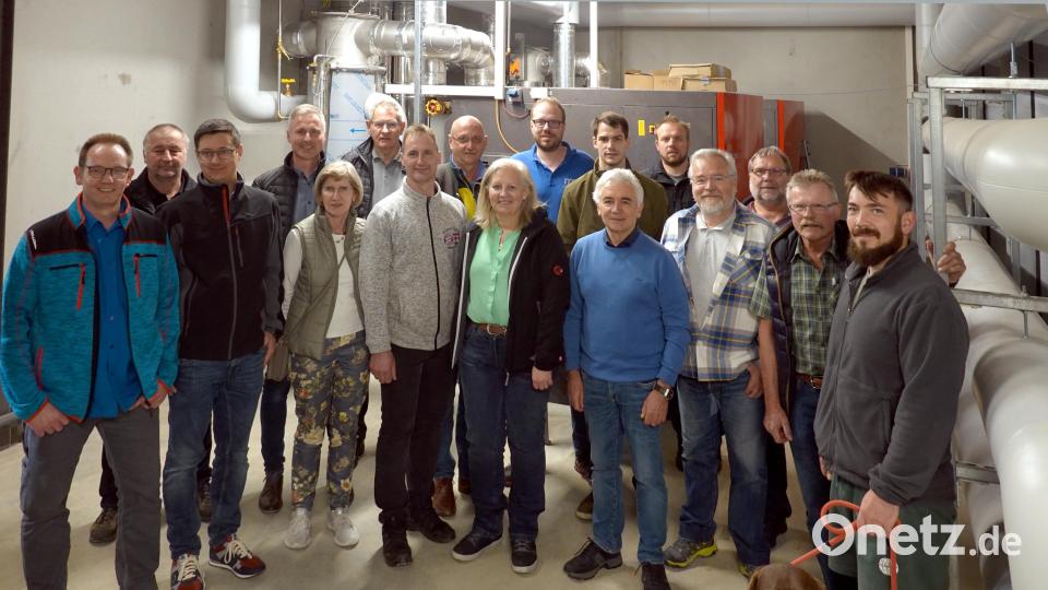 Michael Rädle (hintere Reihe, Mitte) erläutert den Besuchern die Anlage. Im Hintergrund die beiden Heizkessel, rechts die Wärmespeicher. Bild: gac