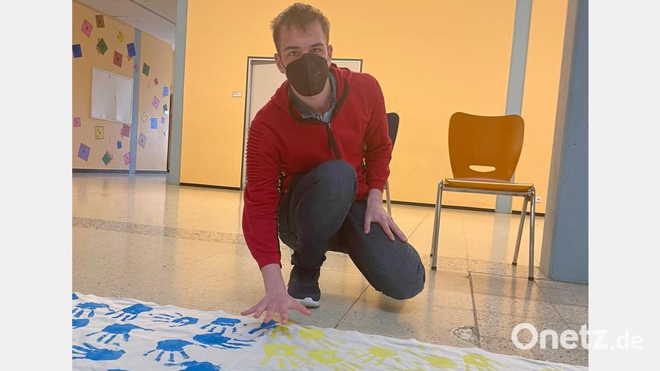 Der erste ukrainische Schüler durfte in gleich beiden Farben die ukrainische Flagge ergänzen Bild: Lena Pöllath/exb